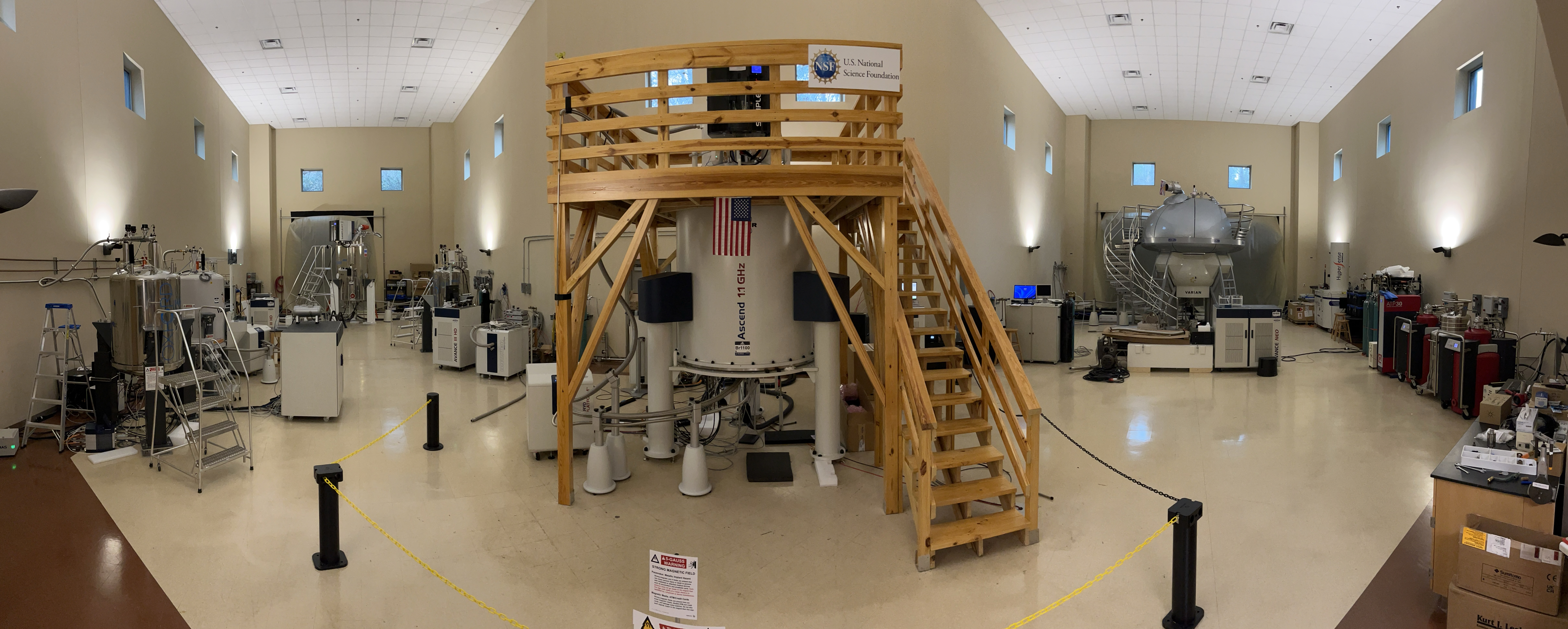 06Jan2026_Lab_panorama A wooden ladder with a white cylinder and a white flag on it, resembling equipment found in a Nuclear Magnetic Resonance (NMR) Facility.